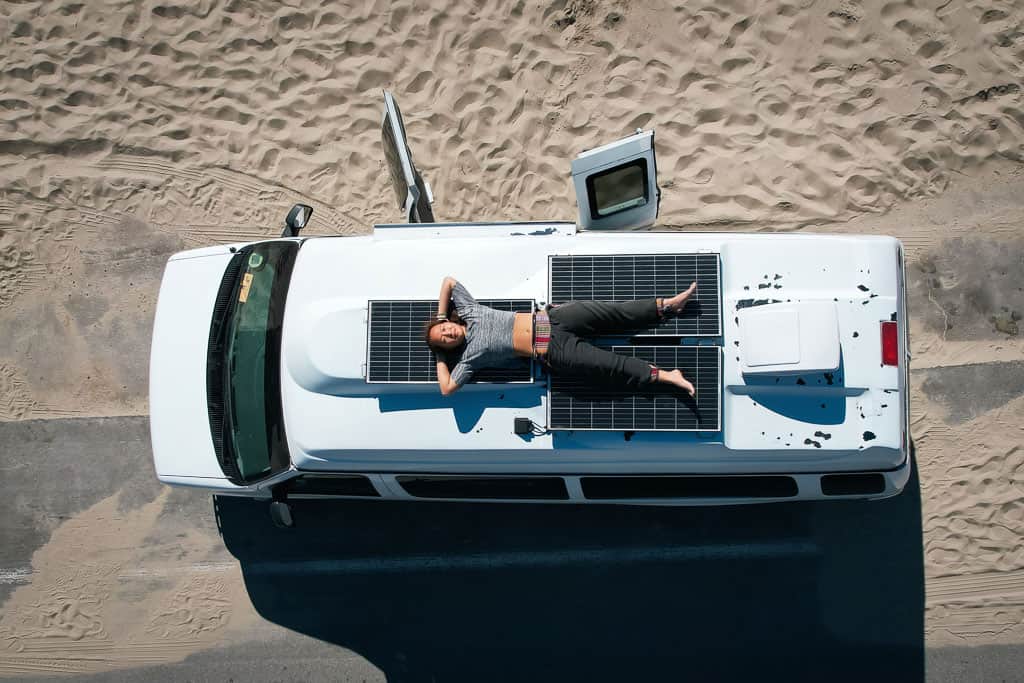 girl lying on top of a camper van