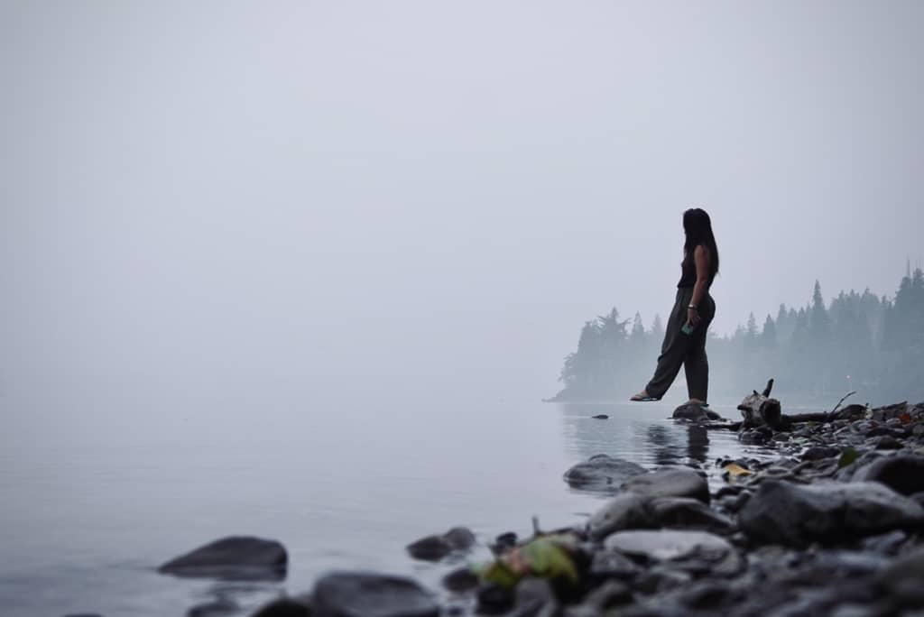 girl on a lake in wildfire fog