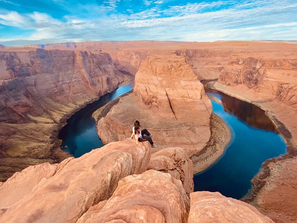 girl sitting on horseshoe bend panoramic views having completed a road trip from Las Vegas to page az