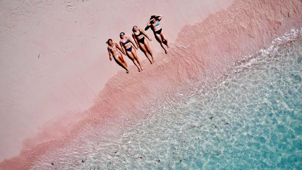four girls lounging on pink beach in komodo national park