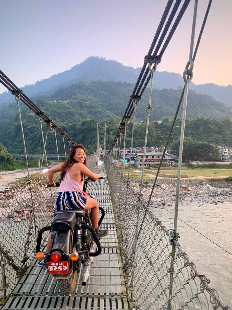 riding a motorcycle on a suspension bridge