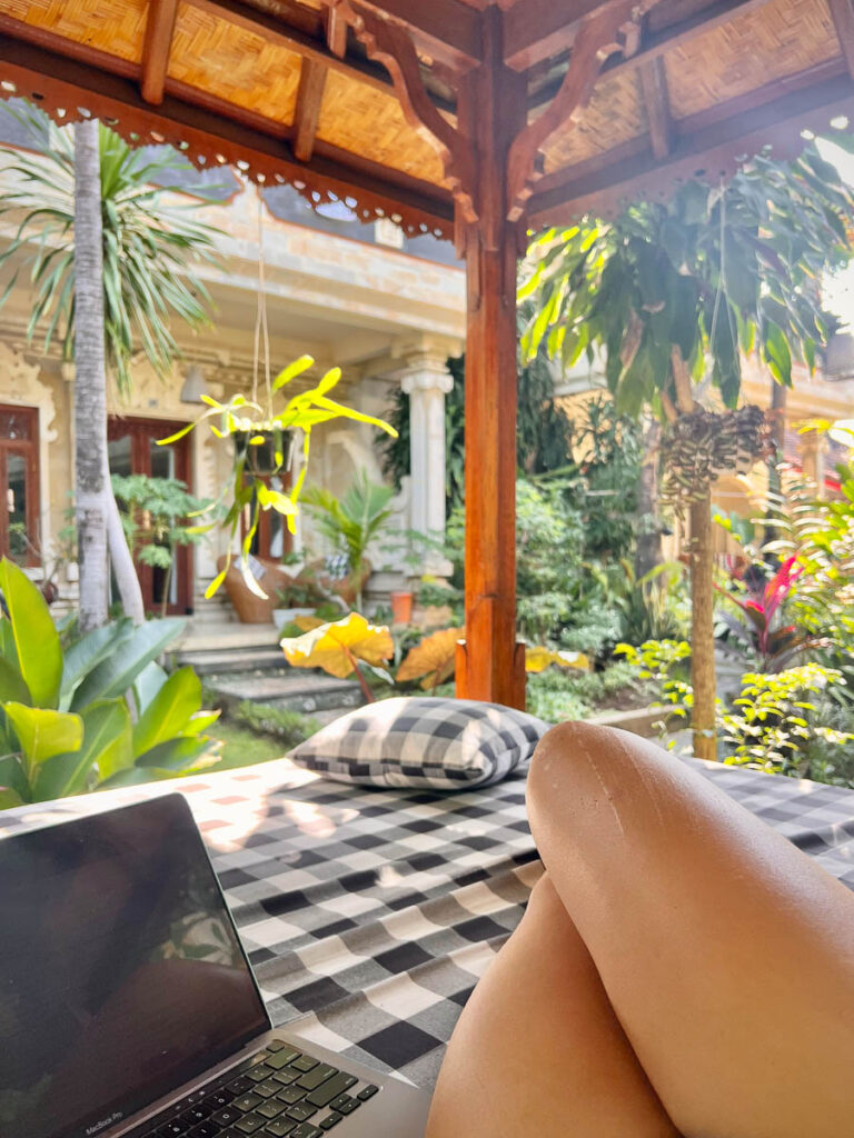 Nomadicated working on laptop gear while sunbathing in Bali, Indonesia