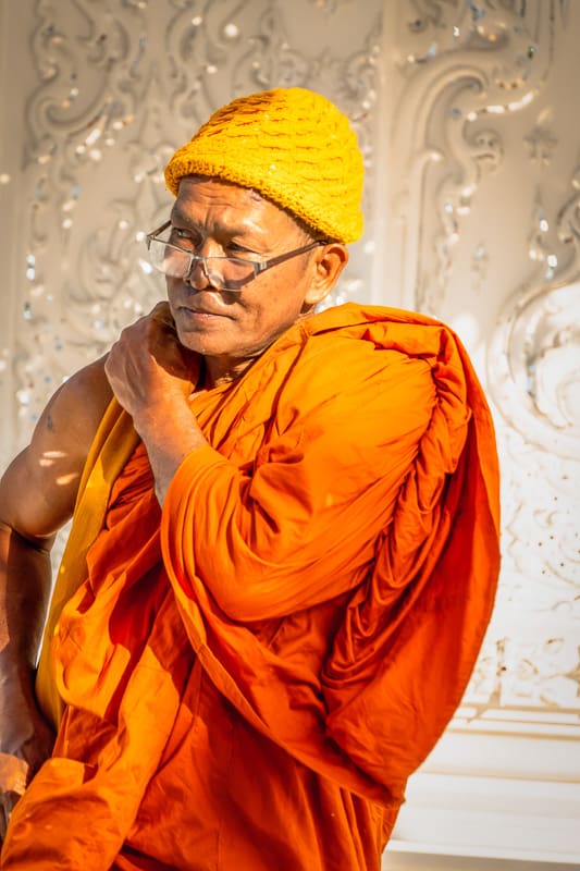 elderly monk in golden hour in Wat Rong Khun chiang mai