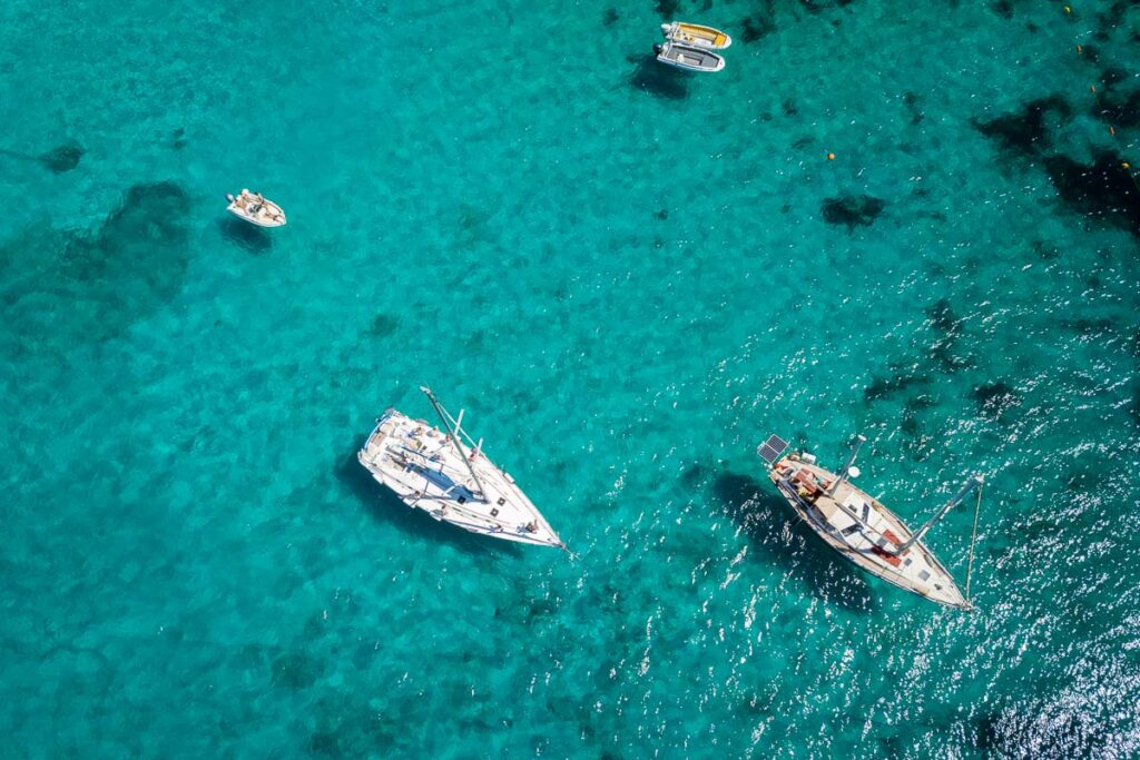 birds eye view of the boats anchored in blue lagoon in comino island