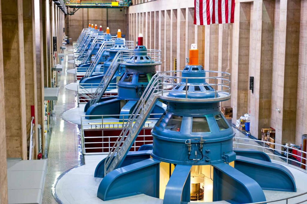 Turbines inside of the historic Hoover Dam plant. Hoover Dam, is a popular tourist destination and was once known as Boulder Dam, is a concrete arch-gravity dam in the Black Canyon of the Colorado River, on the border between the US states of Arizona and Nevada. It was constructed between 1931 and 1936, and was dedicated on September 30, 1935 by President Franklin Roosevelt.