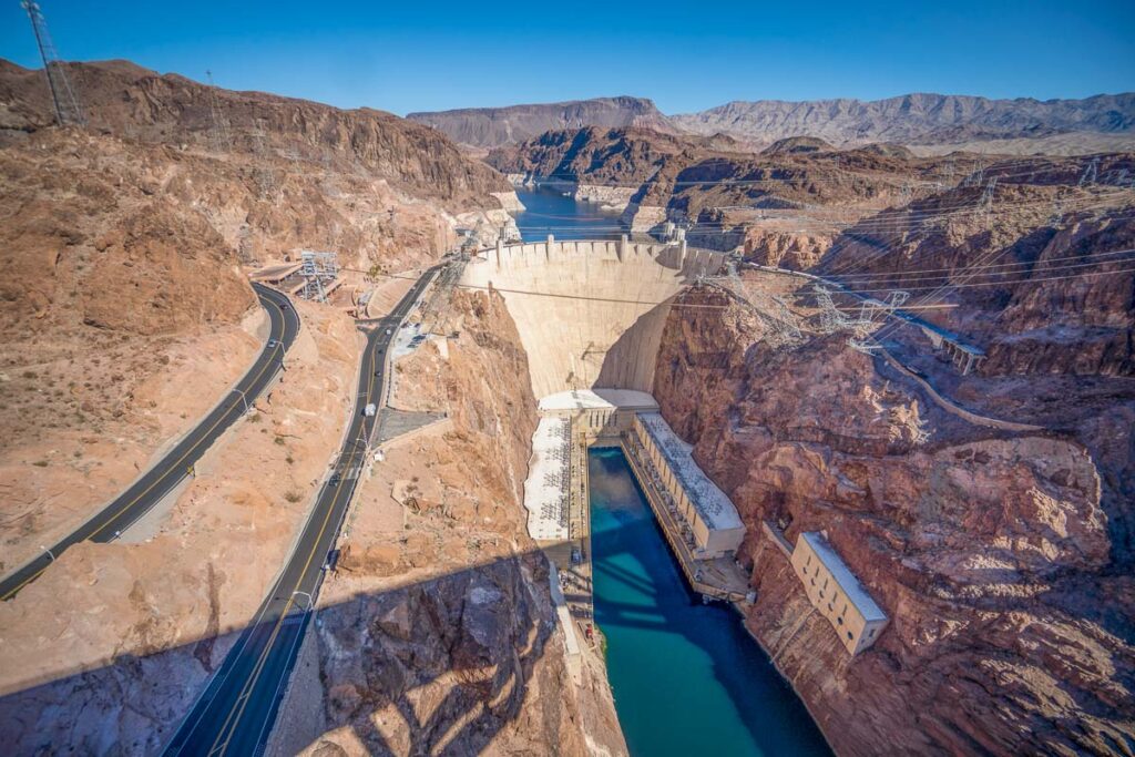 Faraway aerial view of the Hoover Dam from the Bridge surrounded by dessert