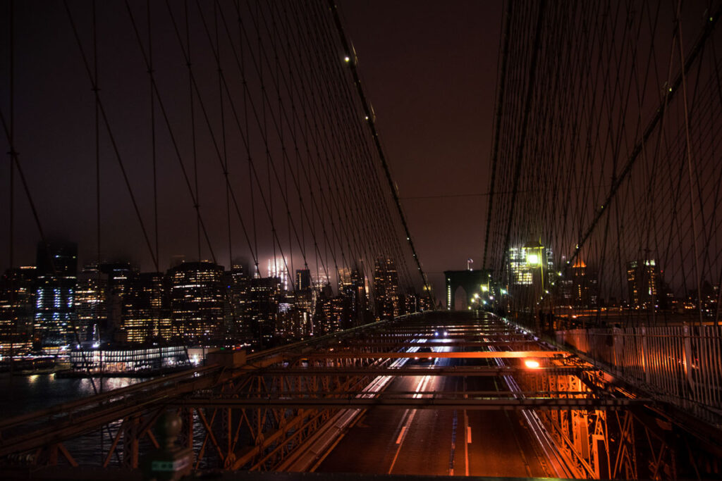 walking across the brooklyn bridge at night