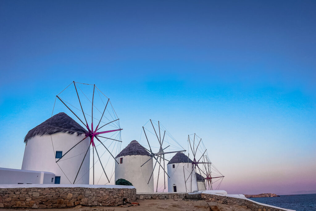 the windmills of mykonos city in the sunrise