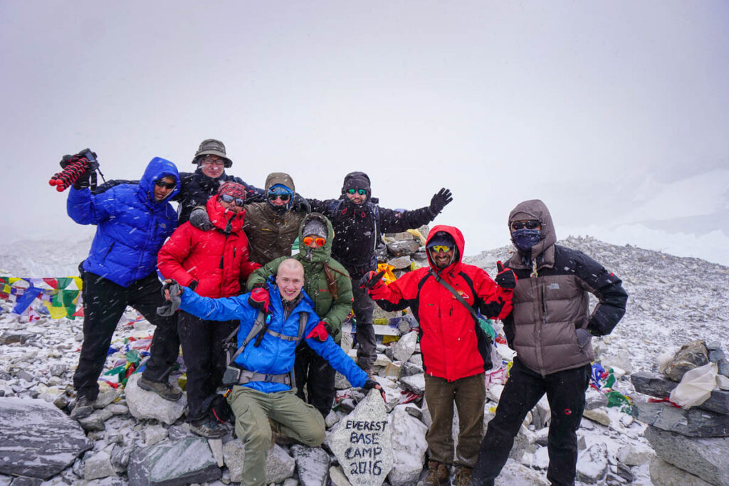 nomadicated at the summit of everest base camp with other adventurer friends
