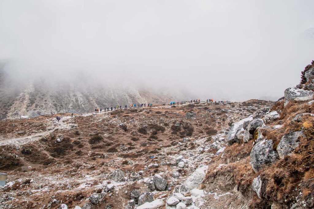 row of trekkers Trekker Crossing a mountain ridge on Everest Trail