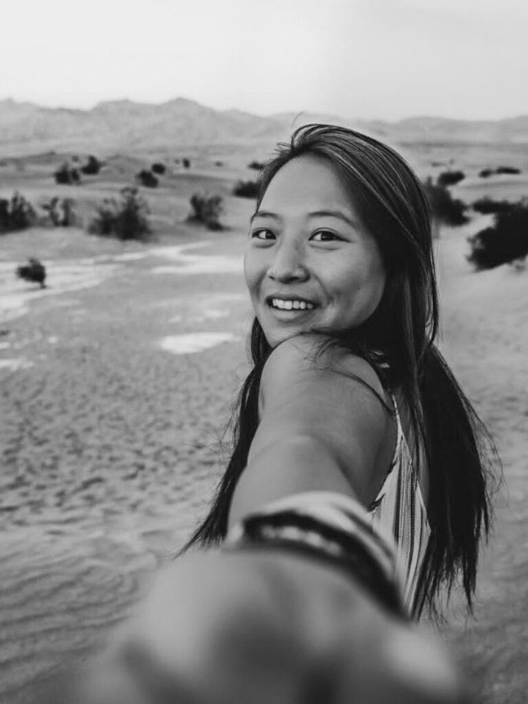catherine xu black and white looking back in a friendly manner grasping your hold in white sands national park