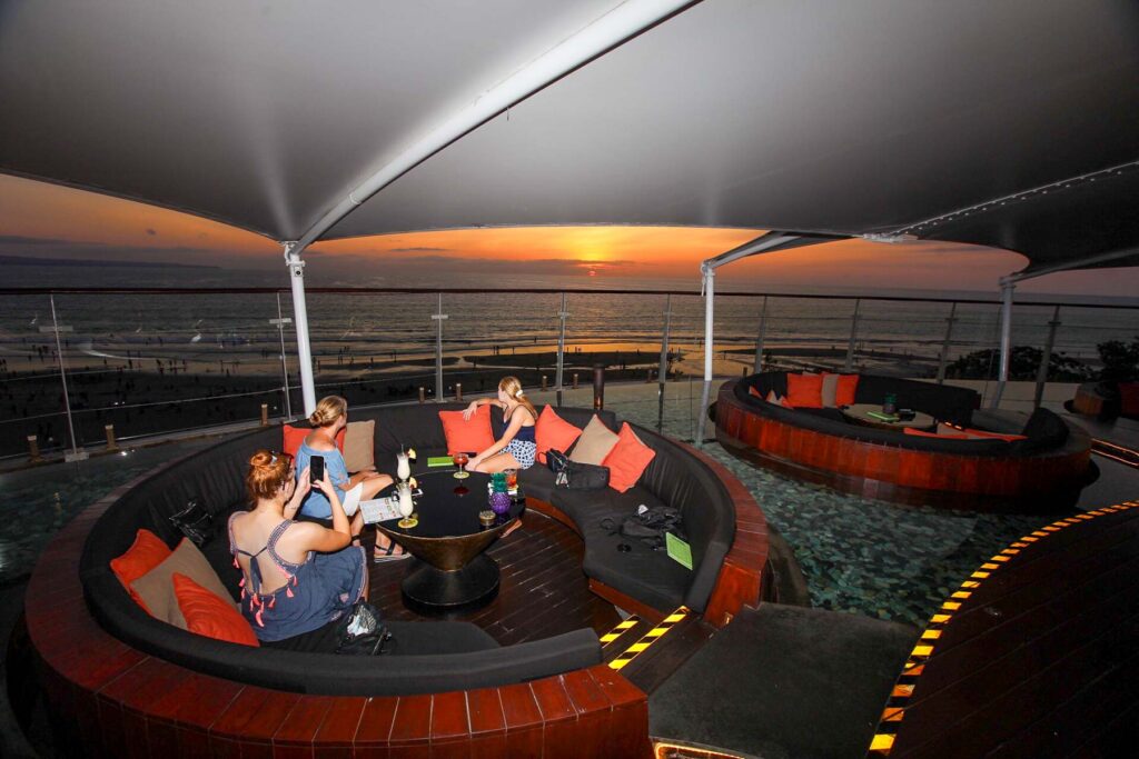 three girls sitting at the sunset of double six rooftop 