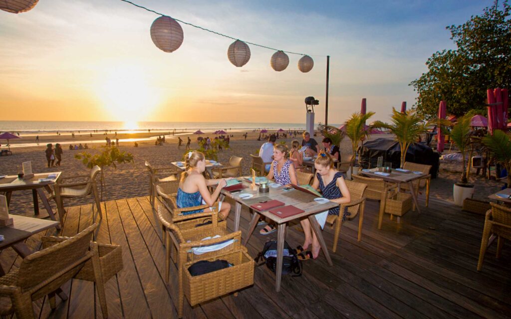 girls sitting at table suring the sunset at woo bar a great thing to do in seminyak at night