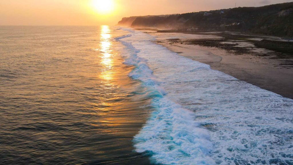 an amazing sunset with the cliffs of bali in the back