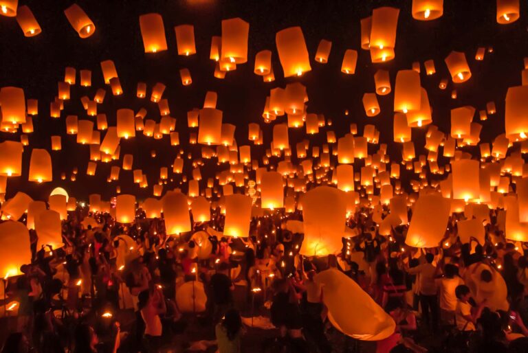 tourists setting lanterns up in lantern festival in thailand