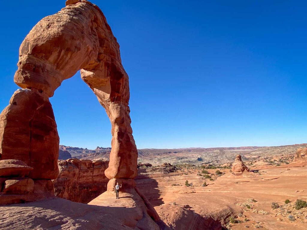 Catherine Xu standing under delicate arch in Arches National Park 