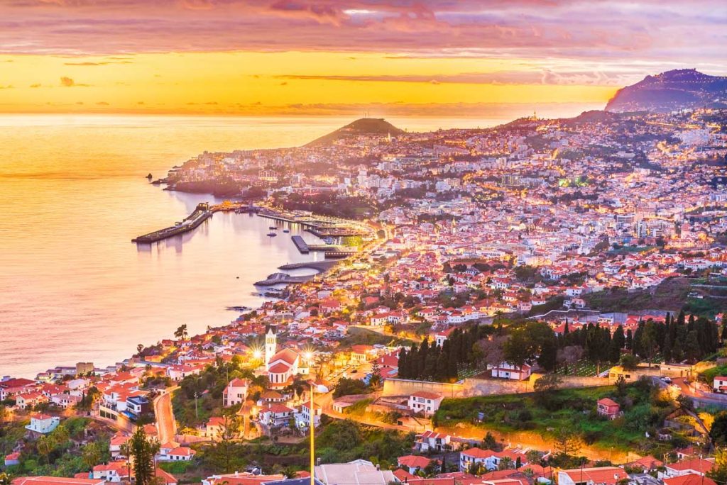 Portugal, Madeira, Funchal coastal city glowing at sunset along the Atlantic shoreline