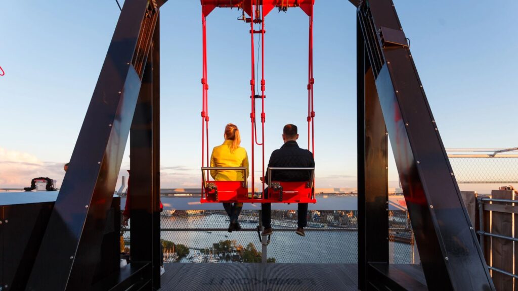 Amsterdam, A'Dam Tower, young couple on the swing on the roof of A'dam tower