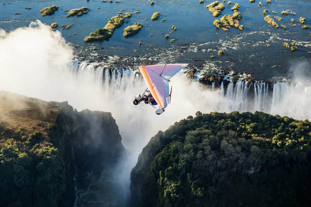 Zambia, Mosi-oa-Tunya, hang glider flying over Victoria Falls gorge and mist