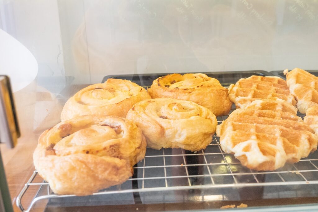 Variety of baked products at a bakery shop,pastries in a bakery window,bakery brown breads to sell,Different types of bread loaves on bakery shelves,Real photo,Template,Copy text space.