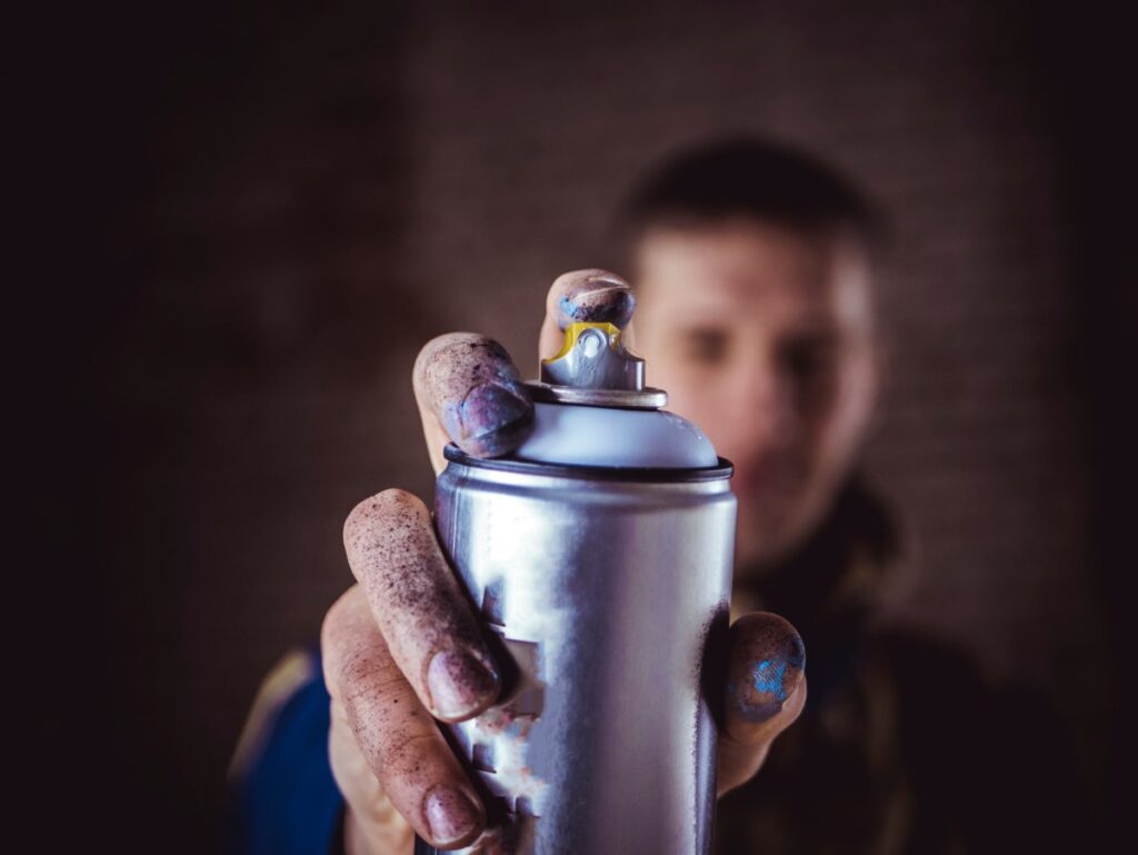 street art artist holding spray paint can in the hand close up