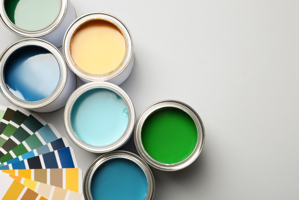 Paint cans and color palette on white background, top view. Spac