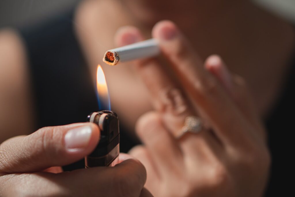 Smoker lighting a cigarette with lighter