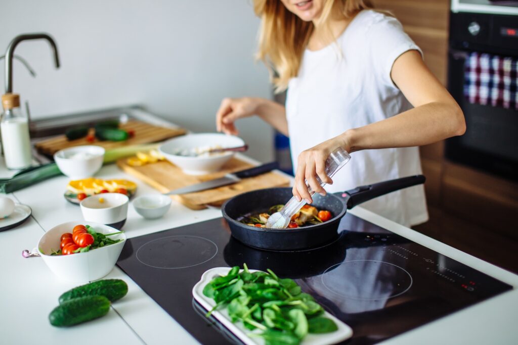 Closeup of woman roasting kebabs on frying pan