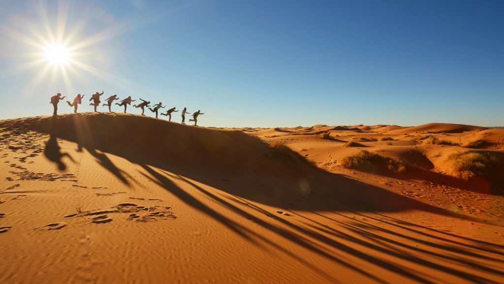 Morocco, Sahara Desert, Tourists enjoy playful moments in the Sahara Desert in Morocco where Marathon des Sables is held