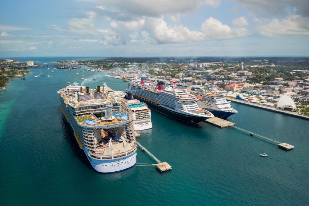 Luxury cruise ships docked at a vibrant port in a tropical destination.