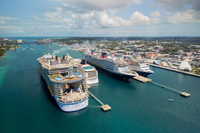 Luxury cruise ships docked at a vibrant port in a tropical destination.