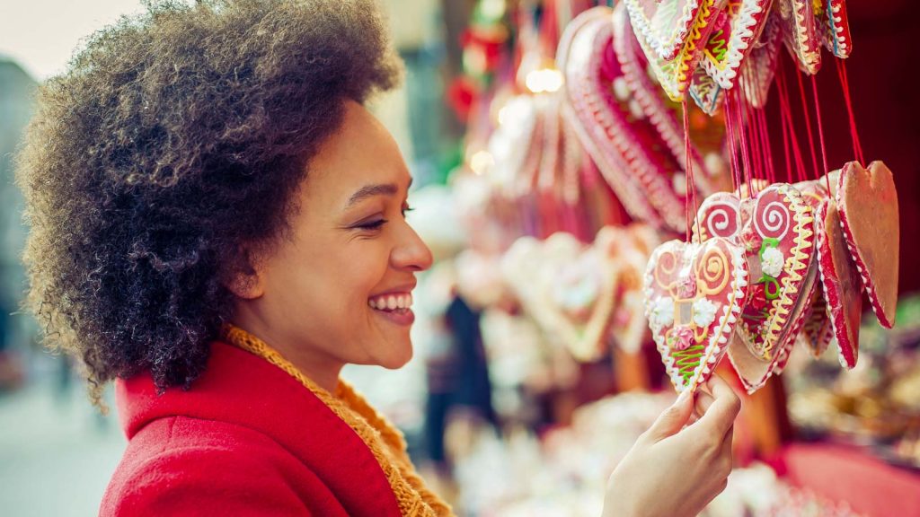 Portret of beautiful woman buying gingerbread hearts in gift shop