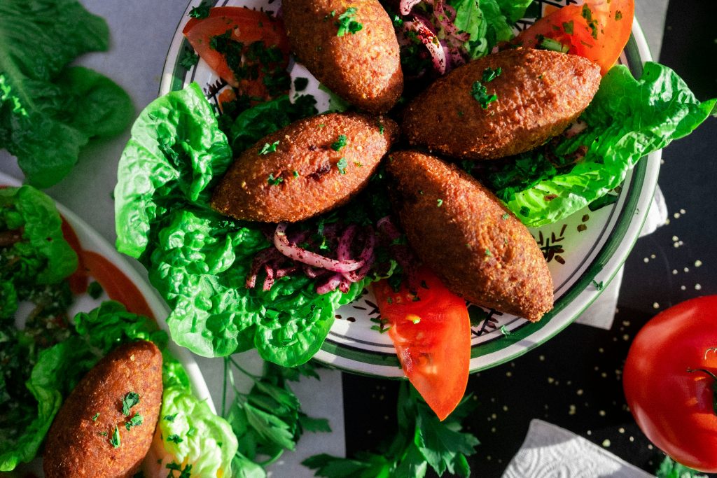 a white plate topped with meat patties and lettuce